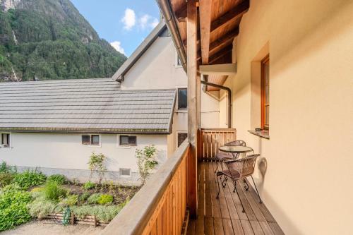 a balcony of a house with a table and a chair at Apartma Miranda in Log pod Mangartom