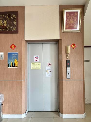 a elevator in a building with a sign on the wall at Pearl Place Hotel in Hat Yai
