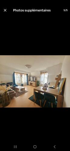 une photo d'un salon avec un bureau dans l'établissement Bel appartement proche CDG-PARIS-ASTERIX, à Marly-la-Ville