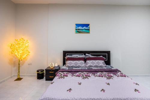 um quarto com uma cama grande com flores em BAITH AL JANNAH Private Family Room em Abu Dhabi