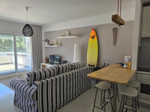 a living room with a couch and a surfboard on the wall at Viana beach apartment in Viana do Castelo