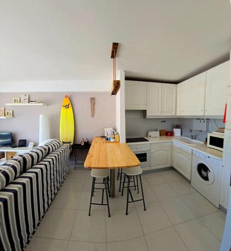 a kitchen with a table and a surfboard on the wall at Viana beach apartment in Viana do Castelo