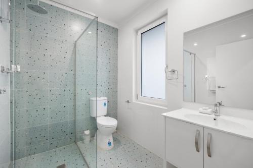 a bathroom with a toilet and a glass shower at Best Western Adelaide Airport in Adelaide