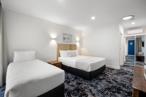 a hotel room with two beds and a bathroom at Best Western Adelaide Airport in Adelaide