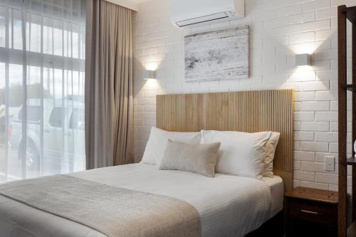 a bedroom with a bed with white sheets and a window at Best Western Adelaide Airport in Adelaide