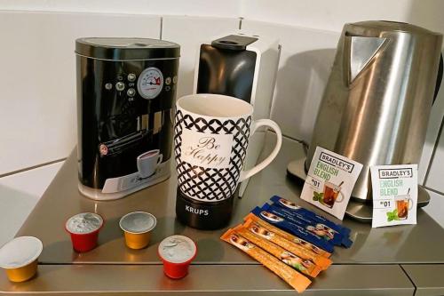 - un comptoir avec une cafetière et une tasse de café dans l'établissement T2 cozy avec parking, terrasse - Severine, à Clermont-Ferrand