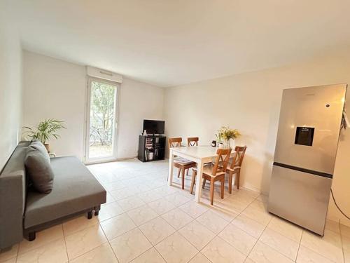 a living room with a table and a refrigerator at Logement entier proche de Paris in Croissy-sur-Seine