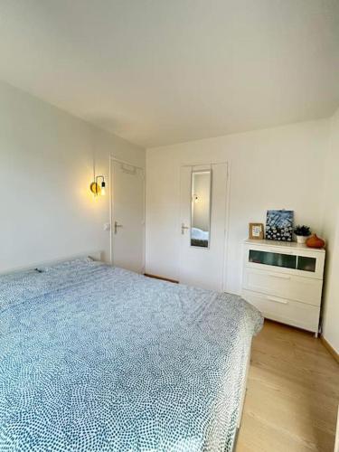 une chambre blanche avec un lit bleu et une armoire dans l'établissement Logement entier proche de Paris, à Croissy-sur-Seine