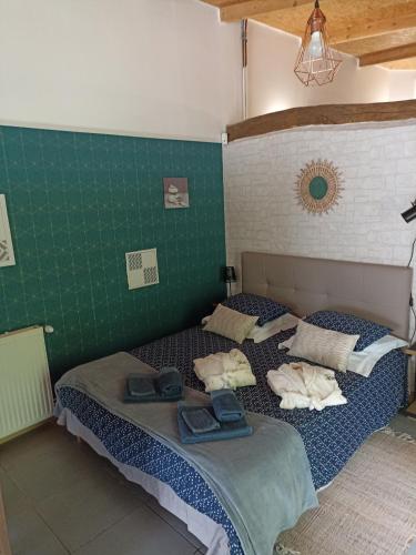 deux lits dans une chambre aux murs verts dans l'établissement La Cordonnerie de Las Places, à Campagne-dʼArmagnac