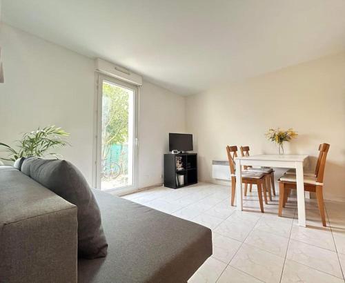 a living room with a couch and a table with chairs at Logement entier proche de Paris in Croissy-sur-Seine