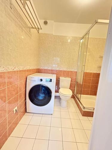 une salle de bain avec machine à laver et toilettes dans l'établissement Logement entier proche de Paris, à Croissy-sur-Seine