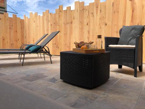 a patio with chairs and a table and a wooden fence at L'alcôve d'Aliénor in Marmande