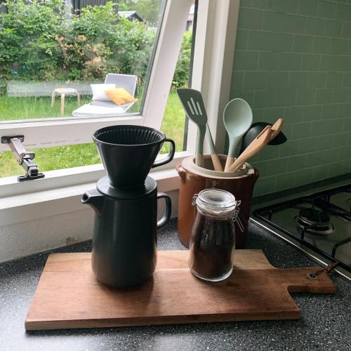 a kitchen counter with utensils on a cutting board at Tiny House op de Veluwe Epe in Epe