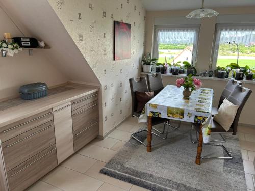a kitchen with a table and chairs and plants at Ferienwohnung Winzenburg Naturnah und ruhig gelegene Ferienwohnung nah am Steinhuder Meer und Dino Park Münchehagen in Rehburg-Loccum