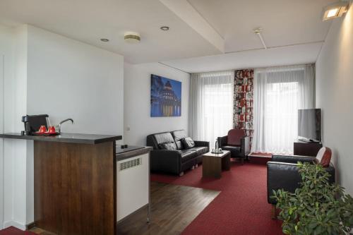a living room with a couch and a table in a room at ARCOTEL Velvet Berlin in Berlin