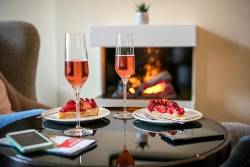 two glasses of wine on a table with two desserts at ARCOTEL Velvet Berlin in Berlin