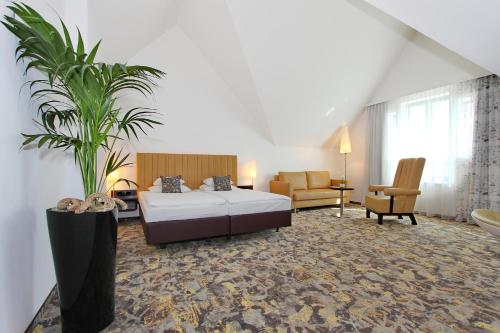a hotel room with a bed and a plant at ARCOTEL Camino Stuttgart in Stuttgart