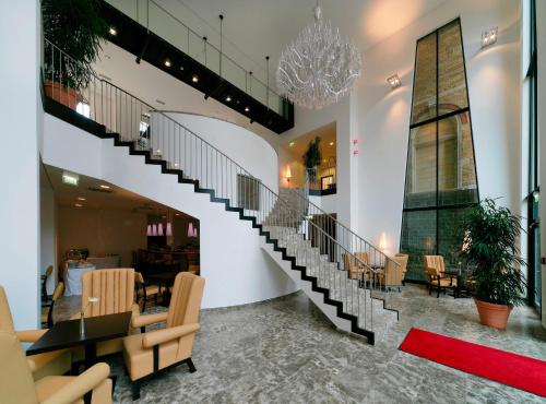 a staircase in a room with a table and chairs at ARCOTEL Camino Stuttgart in Stuttgart