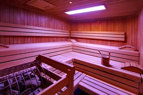 a sauna with wooden walls and benches and a light at ARCOTEL Camino Stuttgart in Stuttgart