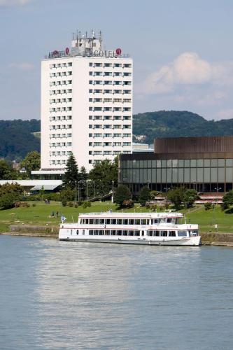 a white boat on the water in front of a building at ARCOTEL Nike Linz in Linz