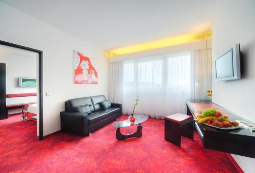 a living room with a couch and a table at ARCOTEL Nike Linz in Linz