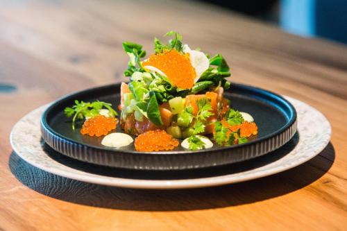 a black plate of food on a wooden table at ARCOTEL Nike Linz in Linz