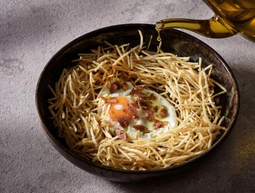 a bowl of spaghetti with an egg on top at Anemelia Hotel Mykonos in Elia Beach
