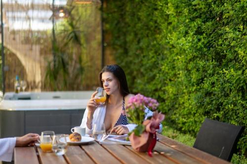 una donna seduta a un tavolo con un bicchiere di vino di Country Home - Kalamata Villas a Kalamáta