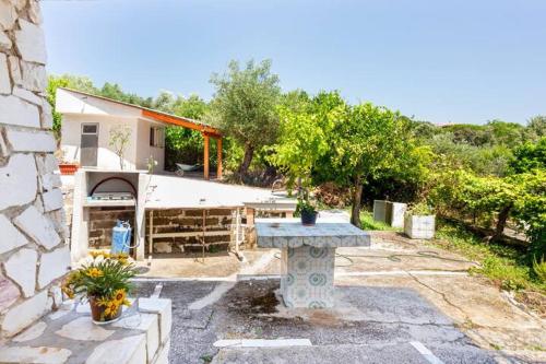 a stone table in front of a house at guesthouseminturnoit Lucia Sparagna in Minturno