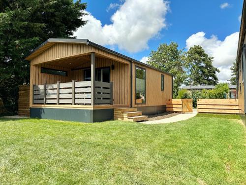 a small wooden building with a grass yard at Chalet 501a op Recreatiepark De Wielen in Sint Maarten