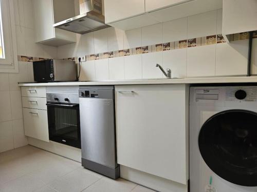 a white kitchen with a dishwasher and a washer at Casa Rovacias Comillas C22A01 in Comillas