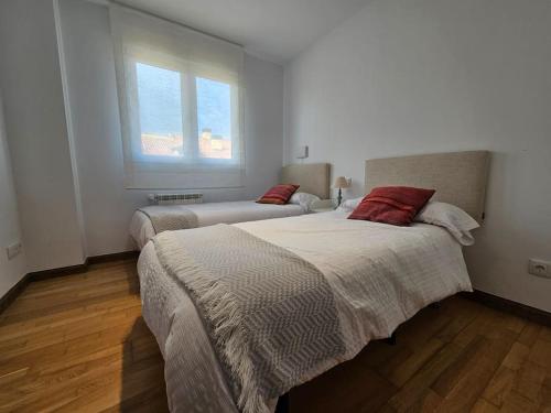 a bedroom with two beds and a window at Casa Rovacias Comillas C22A01 in Comillas