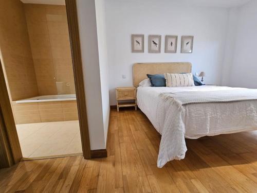 a bedroom with a bed and a bathroom with a tub at Casa Rovacias Comillas C22A01 in Comillas