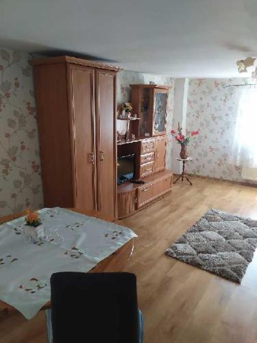 a living room with a table and a cabinet at Jagiellonka in Inowrocław