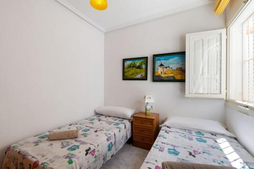 een slaapkamer met 2 aparte bedden en een raam bij HE La Florida-David in Orihuela-Costa