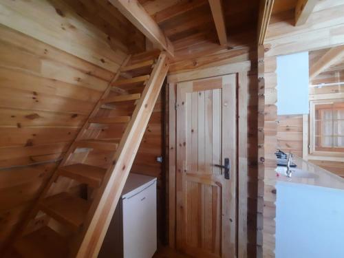a kitchen with wooden walls and a staircase in a tiny house at Adrasan Eren Apart evleri in Adrasan