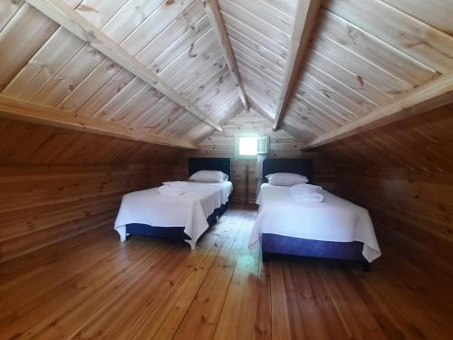 two beds in a room with a wooden ceiling at Adrasan Eren Apart evleri in Adrasan
