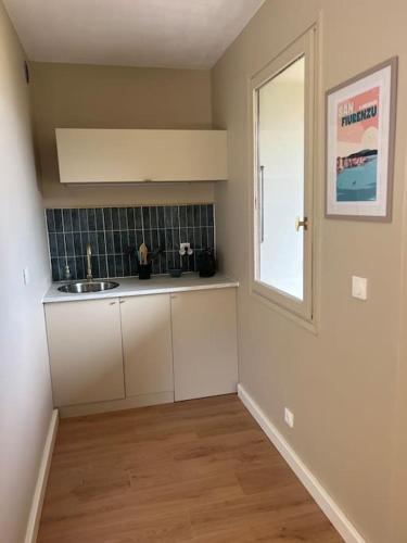 une cuisine vide avec un évier et une fenêtre dans l'établissement Studio Saint Florent, à Saint-Florent