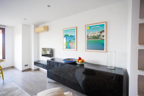 Una sala de estar con un mostrador negro y una mesa. en Casas 349h Explanada Alicante, en Alicante