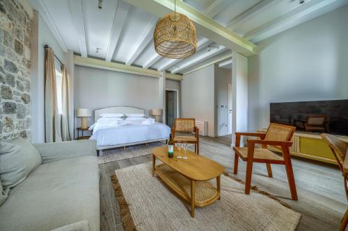 a bedroom with a bed and a couch and a table at Hotel Brattia, Adults Only, Heated Pool, A la Carte Breakfast, Postira, Brač Island in Postira