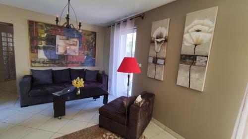 un salon avec un canapé et une chaise dans l'établissement Domaine de Bernassa - Intimité et calme au coeur de 20 hectares de nature, à Saint-Hilaire-de-Lusignan