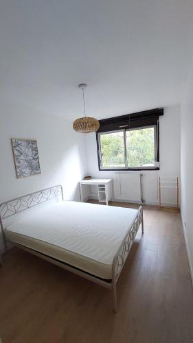 une chambre avec un grand lit blanc dans une pièce dans l'établissement Appartement Montpellier avec piscine, à Montpellier