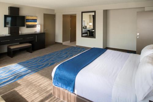a hotel room with a large bed and a desk at The Arch Convention Hotel in Saint Louis