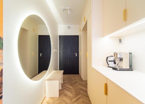 a kitchen with a circular mirror in a room at Apartament Morski Spokój Solny Resort in Kołobrzeg