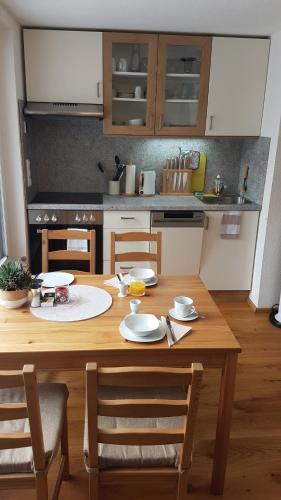 a kitchen with a wooden table with chairs and a tableablish at Apartment Katharina in Spital am Pyhrn