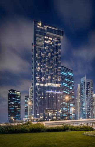 a tall building in a city at night at Taj Jumeirah Lakes Towers in Dubai