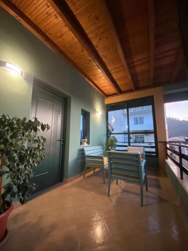 a balcony with two chairs and a table and windows at Vila Ajdinaj in Berat