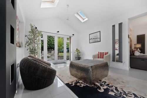a living room with a couch and a ottoman at 3 Bedroom Bungalow Sunningdale Lodge Ascot Races in Sunningdale