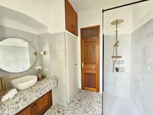 a bathroom with a sink and a mirror and a shower at Maison d Americain a Figarella au Cap Corse in Santa-Maria-di-Lota