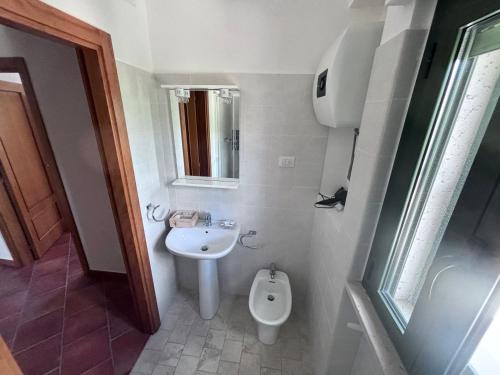 a small bathroom with a toilet and a sink at San Francesco Lodge in Mattinata
